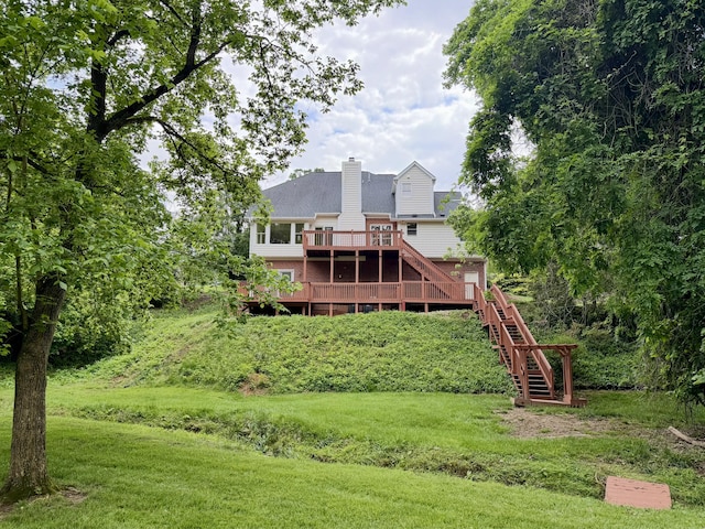 back of house with a wooden deck, stairway, a chimney, and a yard