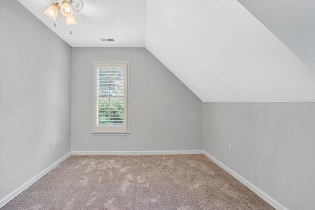 additional living space featuring carpet, lofted ceiling, baseboards, and a ceiling fan