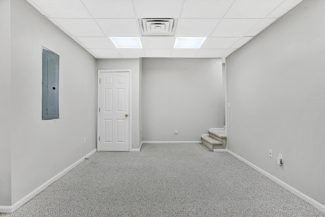 below grade area featuring electric panel, a drop ceiling, carpet floors, and baseboards