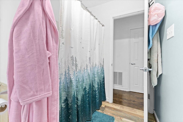 full bath with wood finished floors and a shower with curtain