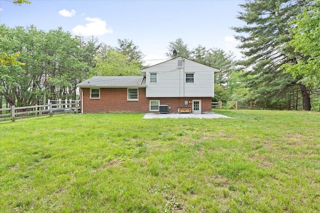 rear view of house with a patio area, cooling unit, brick siding, and view of scattered trees