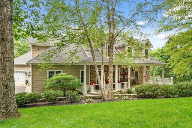 view of front of home featuring a porch, a garage, a front lawn, and a shingled roof
