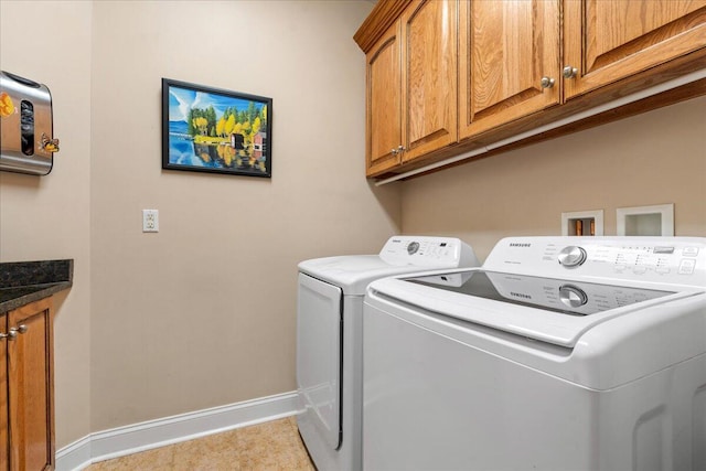 washroom with washing machine and clothes dryer, cabinet space, and baseboards