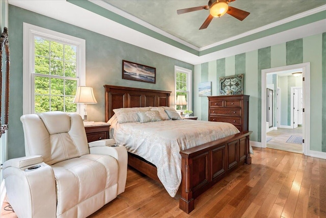 bedroom featuring baseboards, light wood-style floors, multiple windows, crown molding, and wallpapered walls