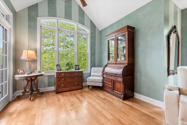 sitting room featuring vaulted ceiling, light wood finished floors, plenty of natural light, baseboards, and a ceiling fan