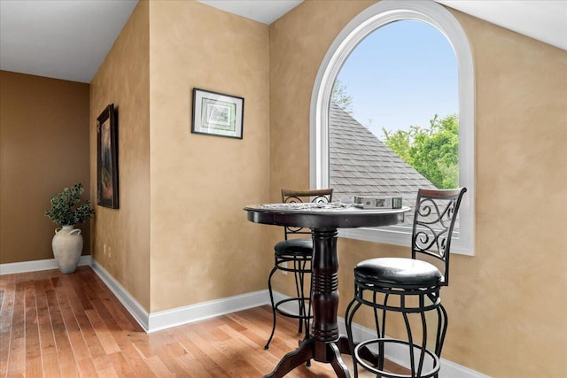 dining space with hardwood / wood-style floors and baseboards