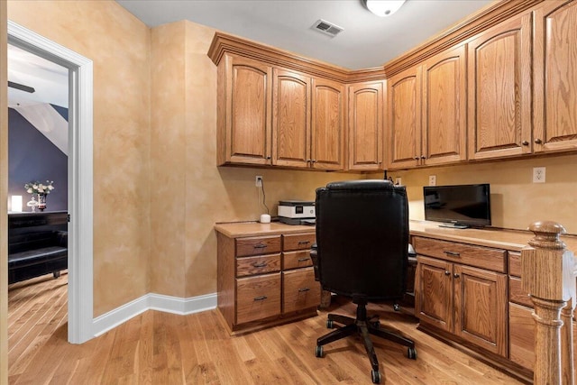 office area with built in study area, light wood-style floors, and baseboards