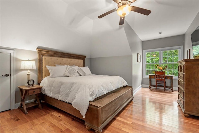 bedroom with light wood-type flooring, ceiling fan, vaulted ceiling, and baseboards