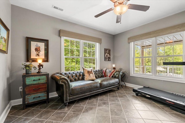 living room with baseboards, ceiling fan, and tile patterned floors
