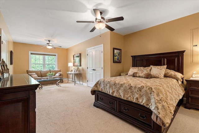 bedroom featuring light colored carpet, ceiling fan, baseboards, and a closet