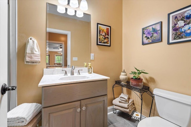 half bath with tile patterned floors, vanity, toilet, and a ceiling fan