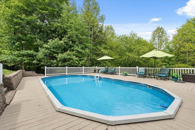 view of pool featuring a deck and view of scattered trees