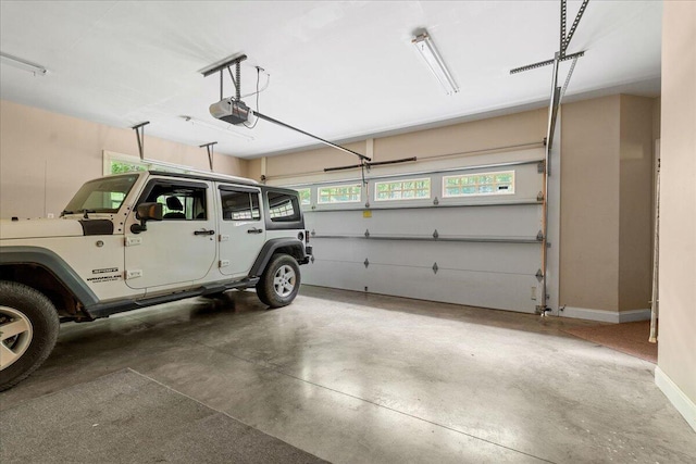 garage featuring a garage door opener and baseboards
