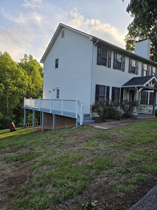 100 View Dr, Goodview, VA 24095 - view of side of home featuring a chimney, a wooden deck, and a yard
