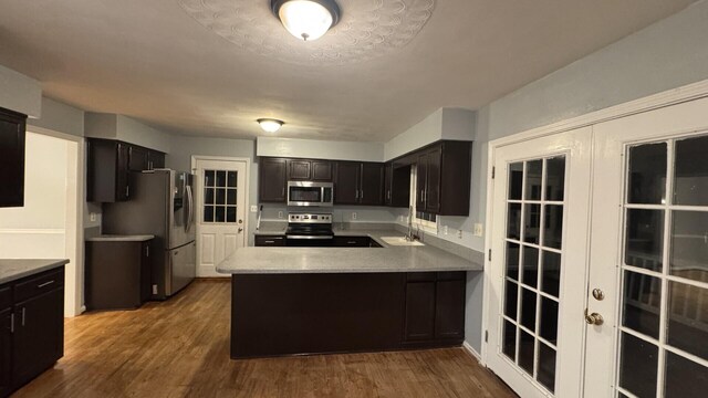 100 View Dr, Goodview, VA 24095 - kitchen featuring stainless steel appliances, light countertops, a peninsula, a sink, and dark wood-style flooring