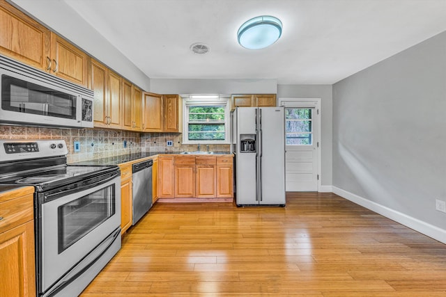 1841 Old Franklin Tpke, Rocky Mount, VA 24151 - kitchen featuring stainless steel appliances, decorative backsplash, baseboards, light wood-style floors, and brown cabinets