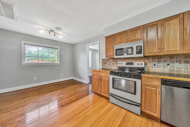 1841 Old Franklin Tpke, Rocky Mount, VA 24151 - kitchen featuring appliances with stainless steel finishes, tile countertops, baseboards, decorative backsplash, and light wood-type flooring