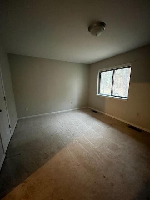 empty room featuring carpet floors and baseboards