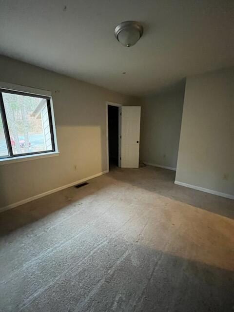 carpeted spare room with baseboards