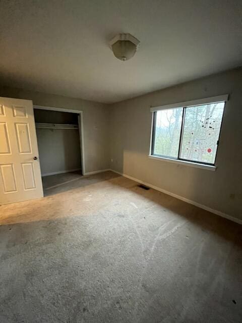 unfurnished bedroom featuring baseboards, a closet, and carpet flooring