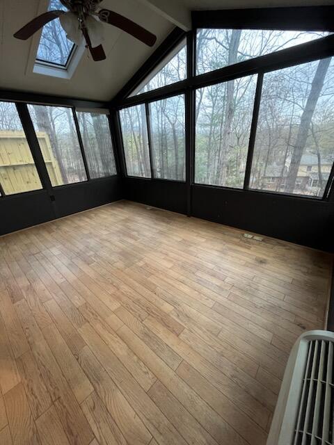 unfurnished sunroom with ceiling fan and wood finished floors