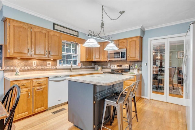 6553 Pencheck Cir, Roanoke, VA 24018 - kitchen with stainless steel appliances, light wood finished floors, crown molding, a breakfast bar, and a kitchen island