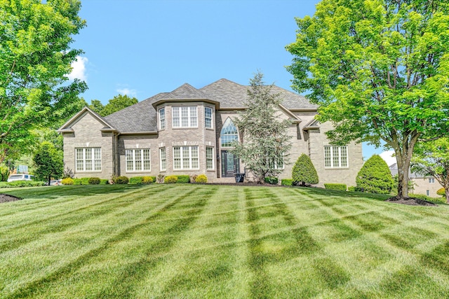 french country style house with a front lawn and brick siding