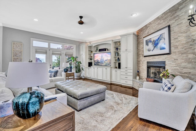 living room featuring dark wood-style floors, crown molding, a fireplace, and recessed lighting