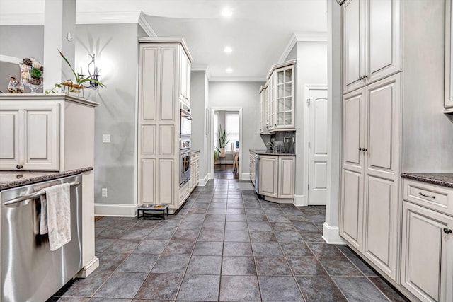 kitchen featuring crown molding, stainless steel appliances, baseboards, glass insert cabinets, and dark stone counters