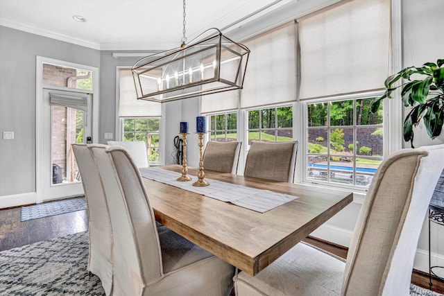 dining area featuring baseboards, wood finished floors, crown molding, a chandelier, and recessed lighting