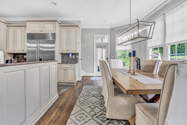 dining area featuring crown molding, a chandelier, dark wood finished floors, recessed lighting, and baseboards