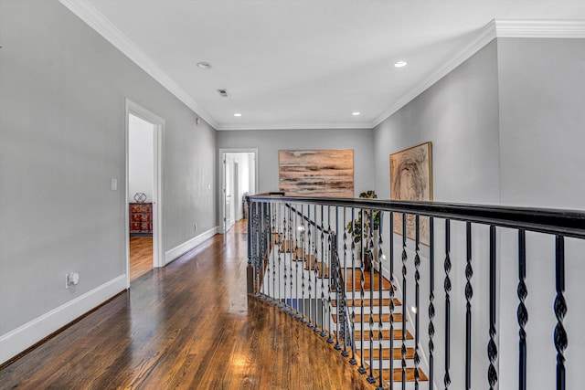 hallway with wood finished floors, recessed lighting, an upstairs landing, baseboards, and ornamental molding