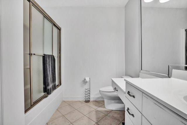 bathroom featuring shower / bath combination with glass door, tile patterned flooring, vanity, toilet, and baseboards