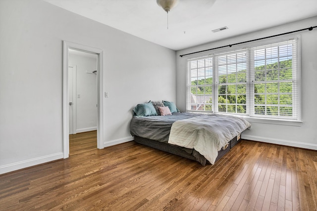 bedroom with hardwood / wood-style flooring, baseboards, and a ceiling fan