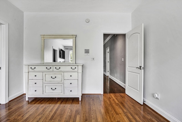 bedroom with dark wood finished floors and baseboards