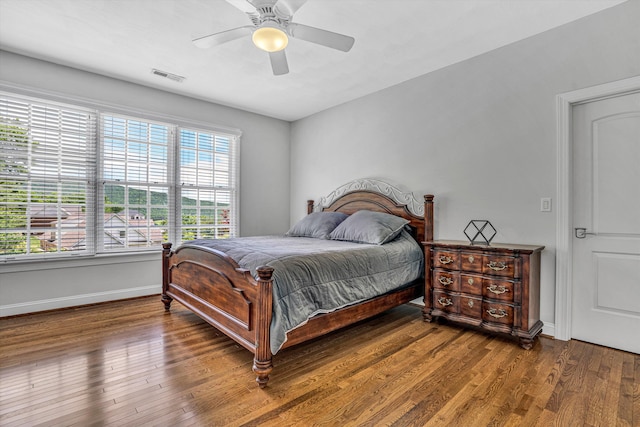 bedroom featuring baseboards, wood finished floors, and ceiling fan