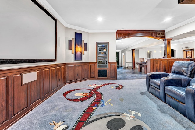 carpeted cinema featuring decorative columns, ornamental molding, recessed lighting, and wainscoting
