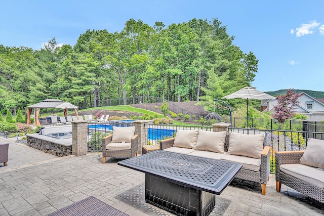 fenced backyard with an outdoor living space, a gazebo, a patio area, and a hot tub