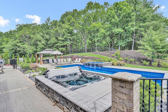view of pool featuring an in-ground hot tub, a gazebo, and a patio area