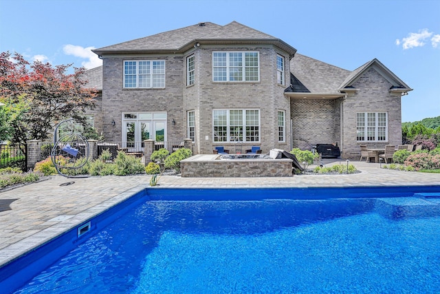 outdoor pool with a patio area and an outdoor fire pit
