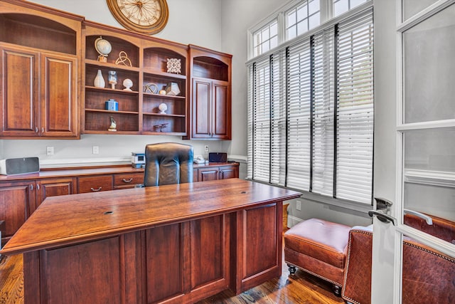 home office featuring dark wood-style floors and built in study area