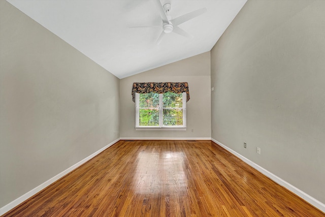 spare room with ceiling fan, wood finished floors, baseboards, and lofted ceiling