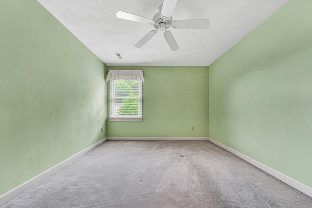carpeted empty room with a ceiling fan and baseboards