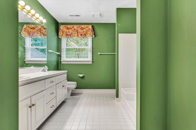 bathroom with tile patterned floors, double vanity, toilet, a bath, and baseboards