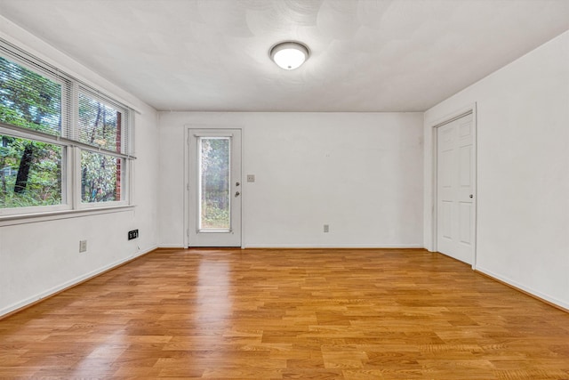 spare room featuring light wood finished floors and baseboards