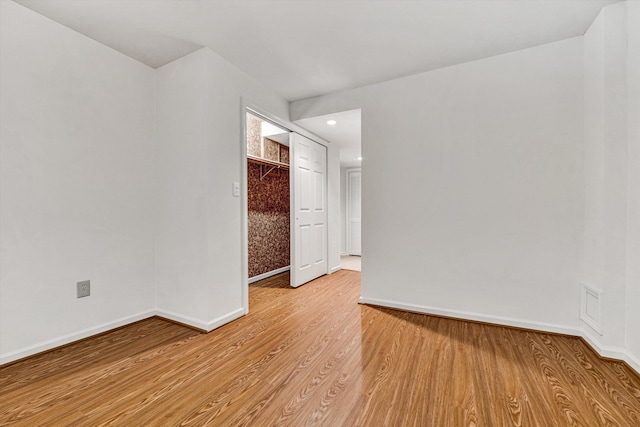 empty room with light wood finished floors, baseboards, and recessed lighting