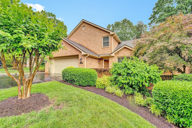 traditional home featuring brick siding, an attached garage, a front yard, driveway, and roof with shingles