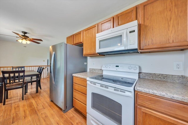 81 Ridgeview Cir, Roanoke, VA 24019 - kitchen with white appliances, light countertops, light wood finished floors, ceiling fan, and brown cabinets