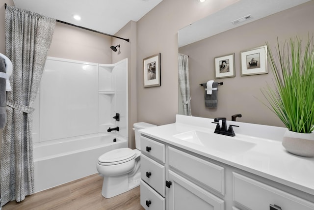 full bath with wood finished floors, toilet, vanity, and shower / tub combo