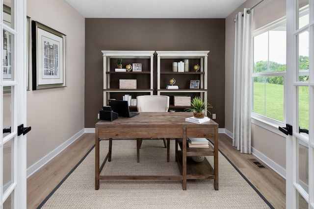 office area featuring french doors, light wood finished floors, and baseboards